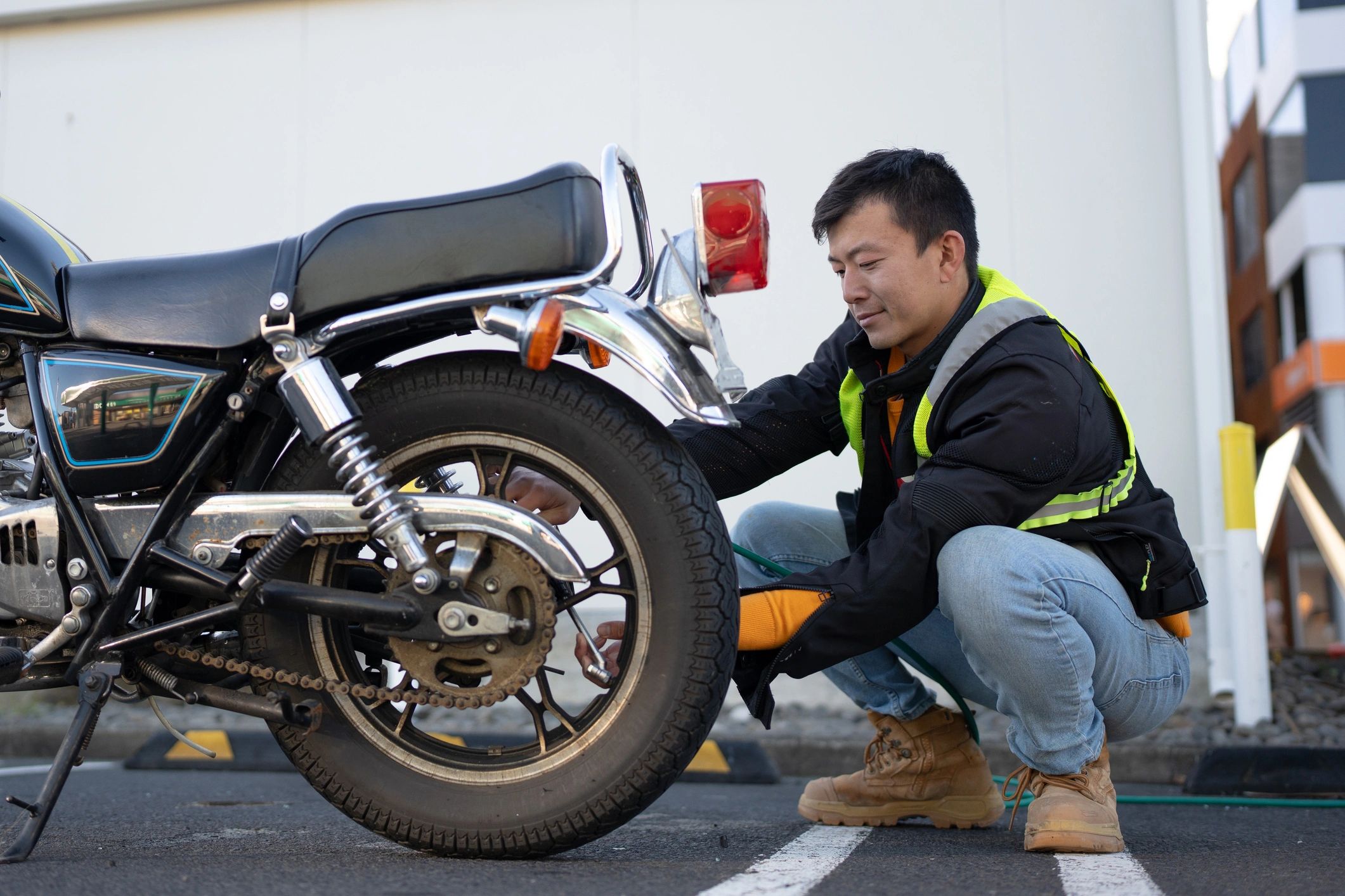 Motorcycle technician inspecting a rear tyre