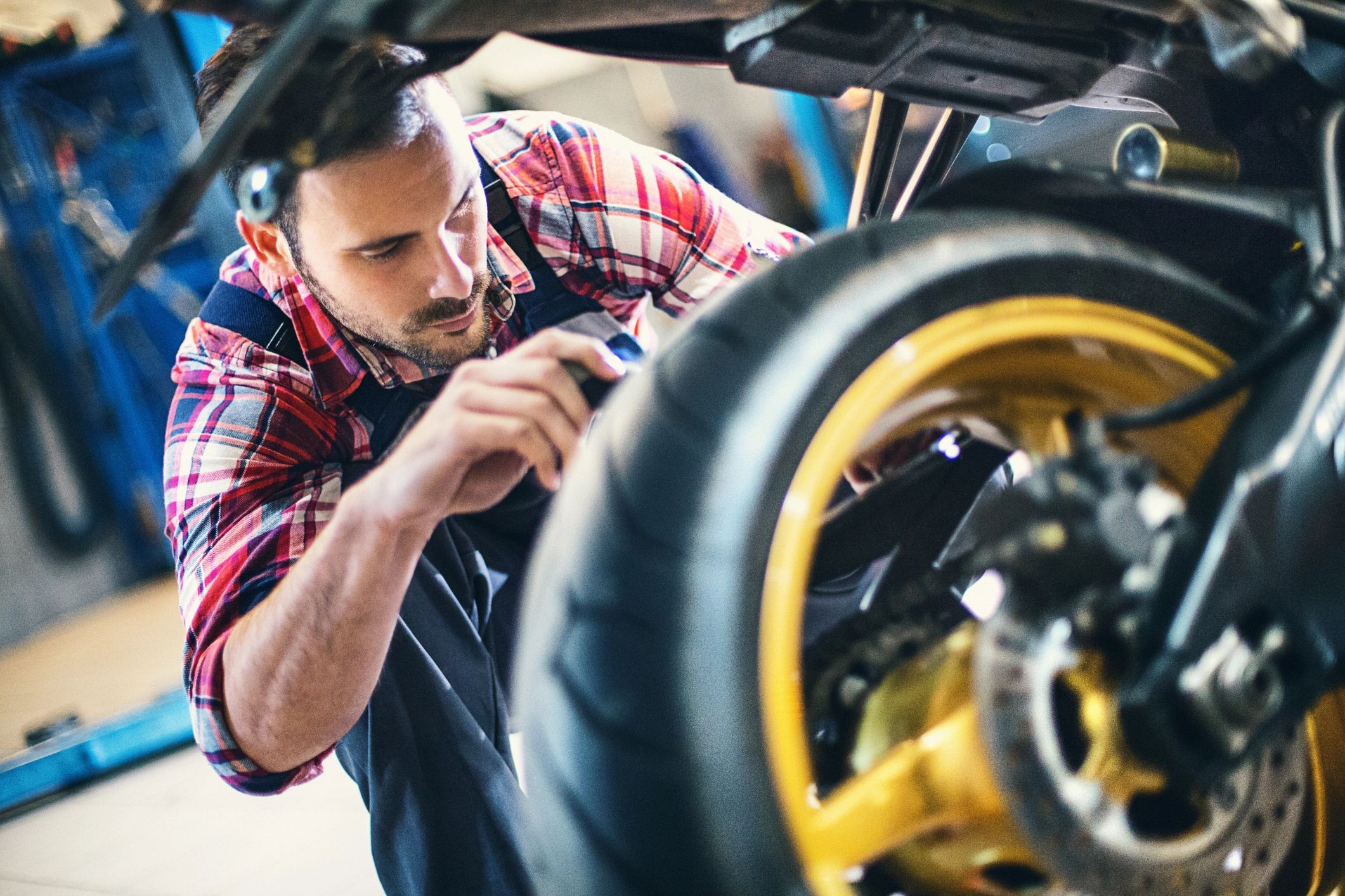 Mechanic servicing a motorcycle in a workshop